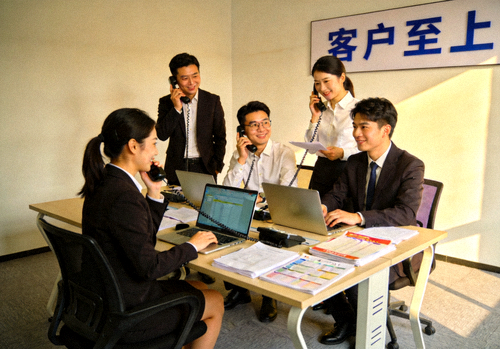 爱游戏体育公司客户服务团队工作场景：团队成员正在会议室中友好地讨论与接听客户电话
