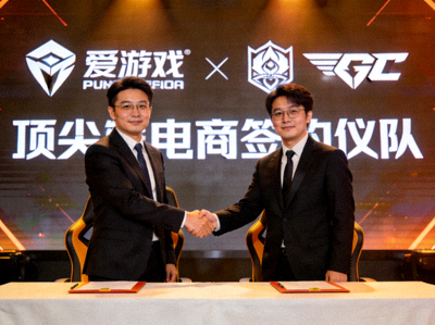 爱游戏与顶尖电竞战队战略合作签约仪式现场：双方代表握手，背景是合作品牌标志