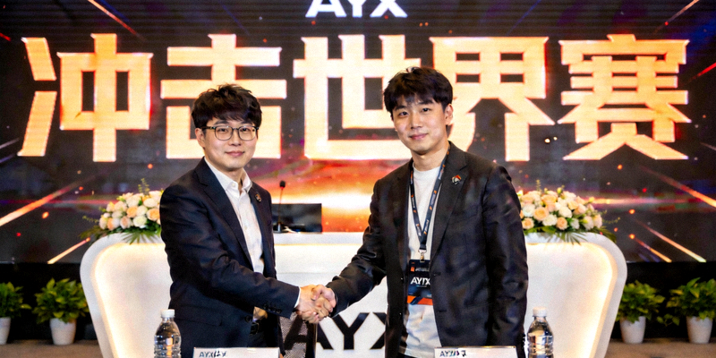 签约仪式现场，AYX体育CEO与明星选手握手，背后大屏幕显示‘冲击世界赛’字样
