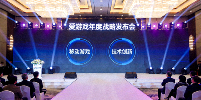 爱游戏年度战略发布会现场，大屏幕显示移动游戏与技术创新关键词