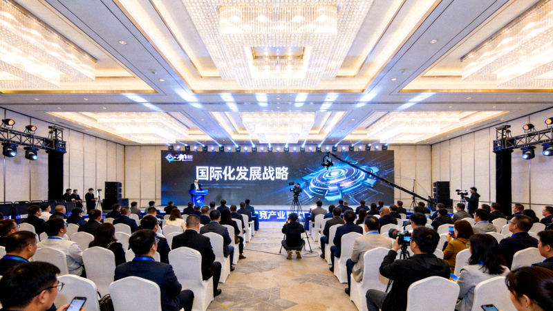 电竞产业峰会现场全景：大屏幕上显示国际化发展战略主题，台下坐满行业嘉宾与媒体记者