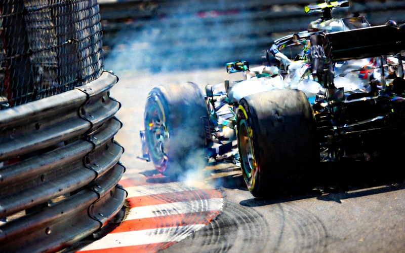 F1大奖赛赛车在赛道上高速过弯的特写画面与赛道旁的防护栏