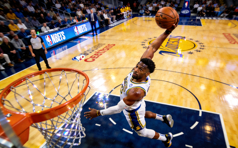 NBA篮球赛场：篮球运动员在比赛中飞身扣篮的瞬间